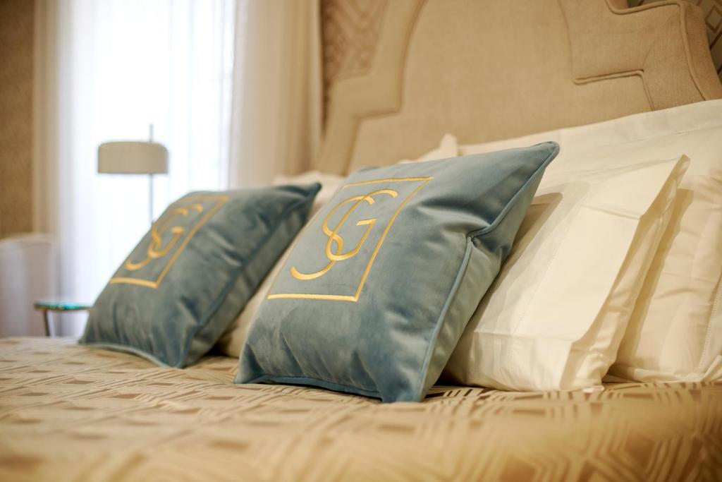 布拉加Signature Apartments Os Terceiros的一张带两个蓝色和白色枕头的床