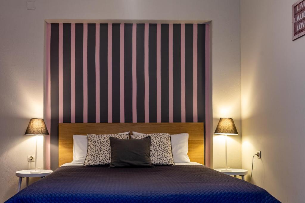 奥林匹亚安尼斯出租客房酒店的一间卧室配有一张带条纹床头板的大床