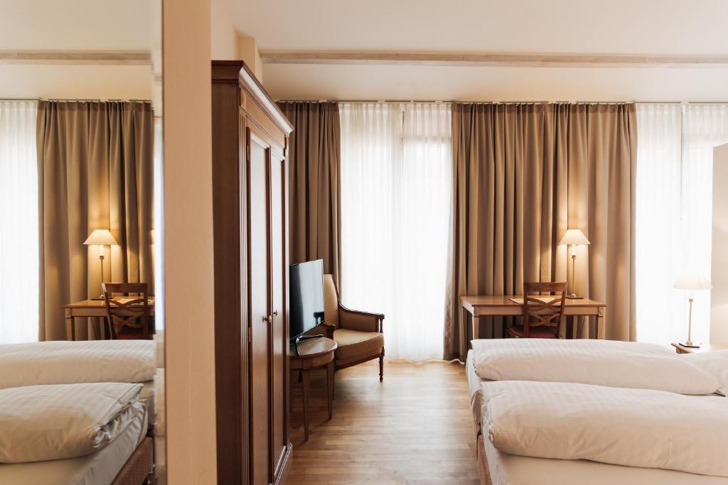 海德堡海德堡考特布拉奥雷酒店的酒店客房设有三张床和电视。