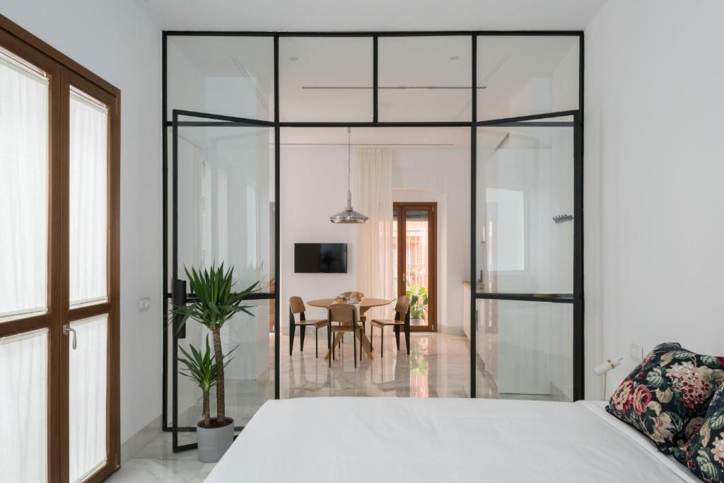 塞维利亚La casa del Lagar 10的一间带白色床的卧室和一间用餐室
