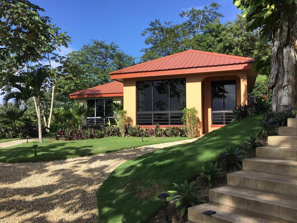 圣伊格纳西奥Villa Cayo的一座红色屋顶和绿色草坪的房子