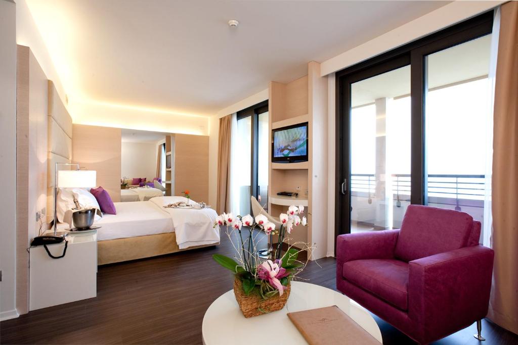格拉多歌德拉古纳宫酒店的酒店客房,配有一张床和一张紫色椅子