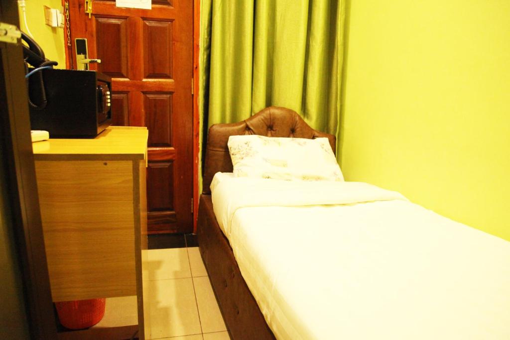 内罗毕Inks Hotel的小房间设有一张床和一张书桌及电视