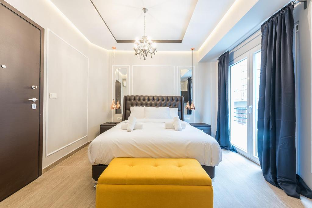 雅典Syntagma Luxury Living One “LL1” Apartments的一间卧室配有一张床和一个黄色的搁脚凳