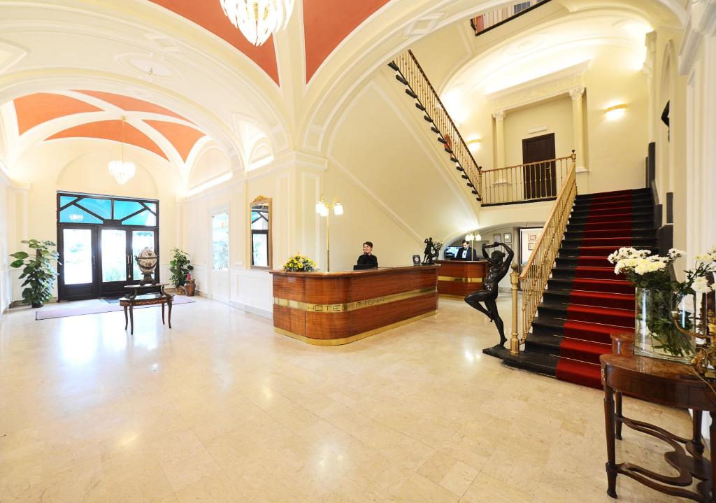 庞贝维多利亚餐厅酒店的大厅,有楼梯,有男人坐在桌子上