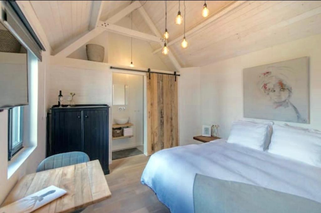 拉纳肯Belle Chique - Maastricht的卧室配有一张白色的大床和一张桌子