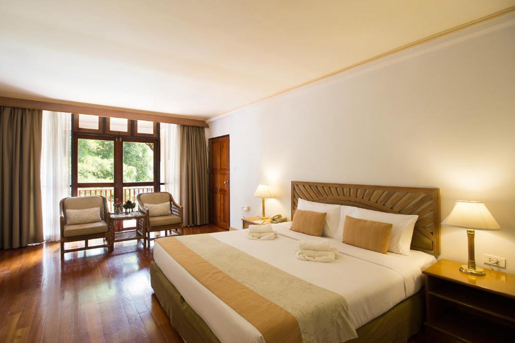 湄宏颂帝国湄宏顺度假酒店的酒店客房带一张大床和两张椅子