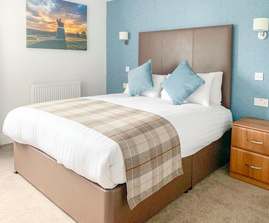 斯特灵罗伯特国王酒店的一间卧室配有一张带蓝色墙壁的大床