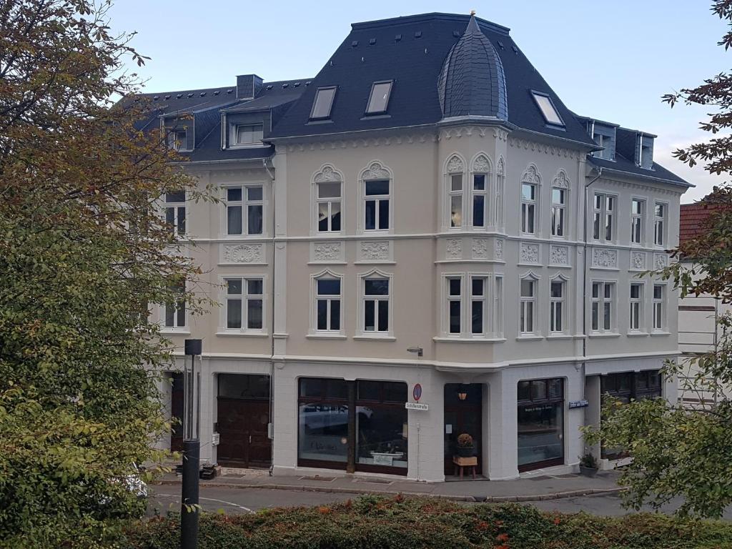 吕登沙伊德Schillers Hotel & Café - GARNI -的黑色屋顶的白色大建筑