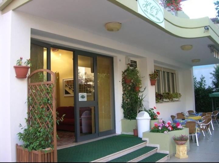 里米尼维塞尔巴卡门酒店的房屋设有带桌椅的庭院
