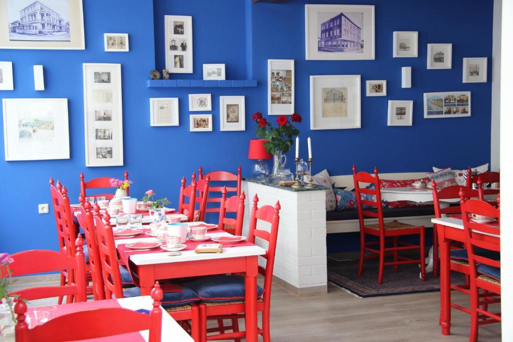 诺德奈Villa Westend的一间设有红色椅子和蓝色墙壁的餐厅