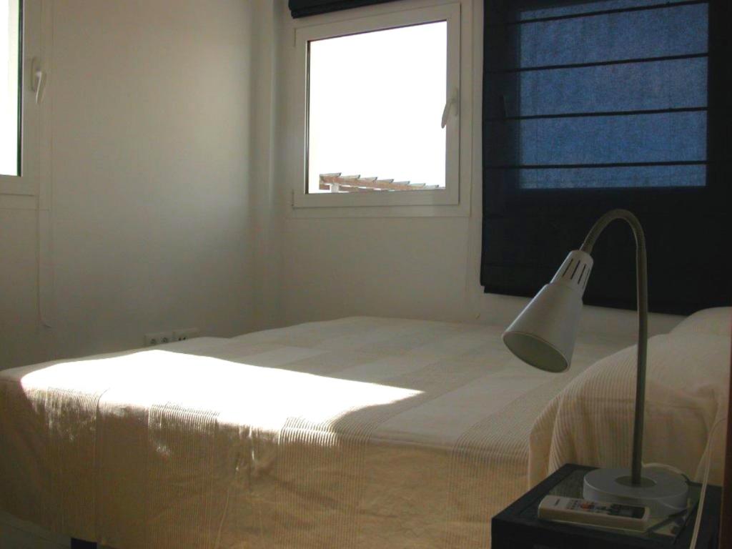 科尼尔-德拉弗龙特拉Apartamentos Guga RTA A CA 00267 AT Edif Complejo 2 Llaves Playa的一间卧室配有一张带灯和窗户的床