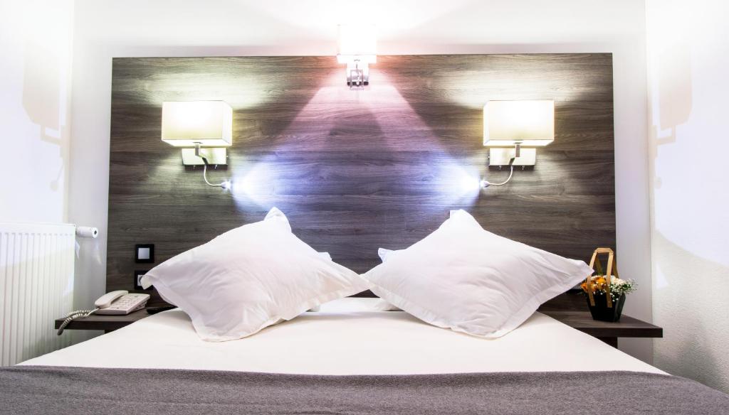 尚贝里尚贝里中心艾拓酒店的一间卧室配有一张大床和两个枕头