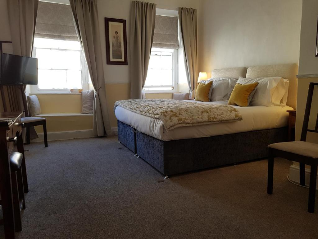 布雷肯Ty Helyg Guest House的一间卧室设有一张大床和两个窗户。
