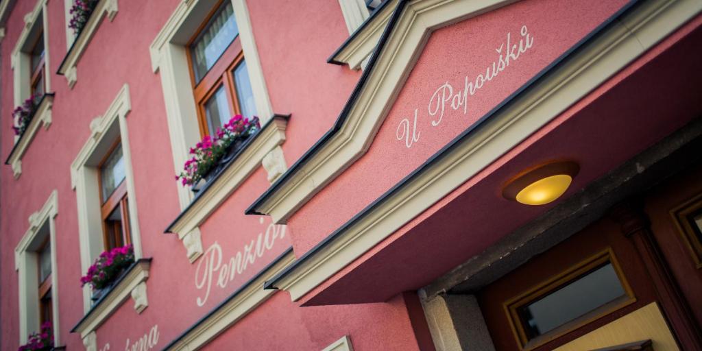 因德日赫城堡尤帕普斯克膳食公寓的粉红色的建筑,花朵在建筑的一侧