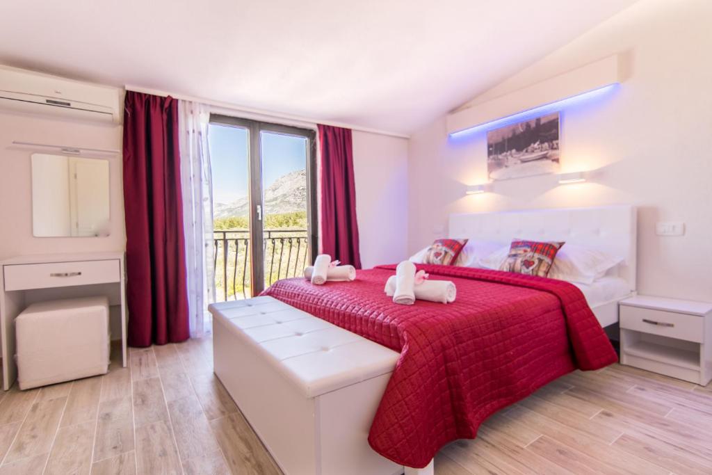 普罗马尼亚Apartments Family Roso的一间卧室配有一张红色床罩的床