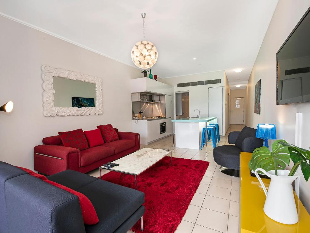 布里斯班米罗公寓酒店的客厅配有红色沙发和红色地毯