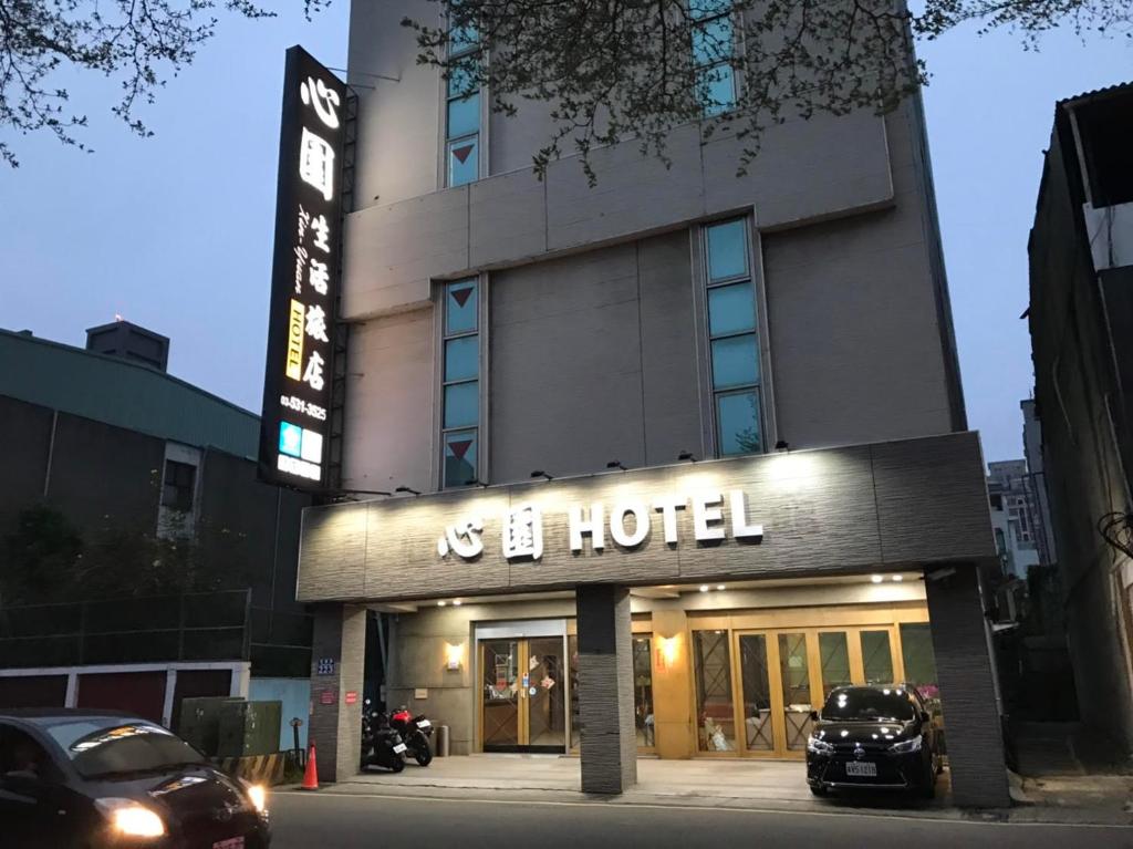 新竹心園生活旅店 Xin Yuan Hotel的前面有停车场的酒店
