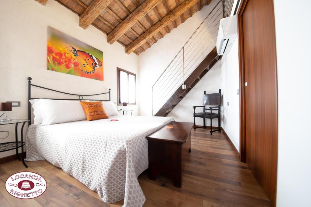 奎托·迪·特雷维索LOCANDA RIGHETTO的一间卧室设有一张床和一个楼梯