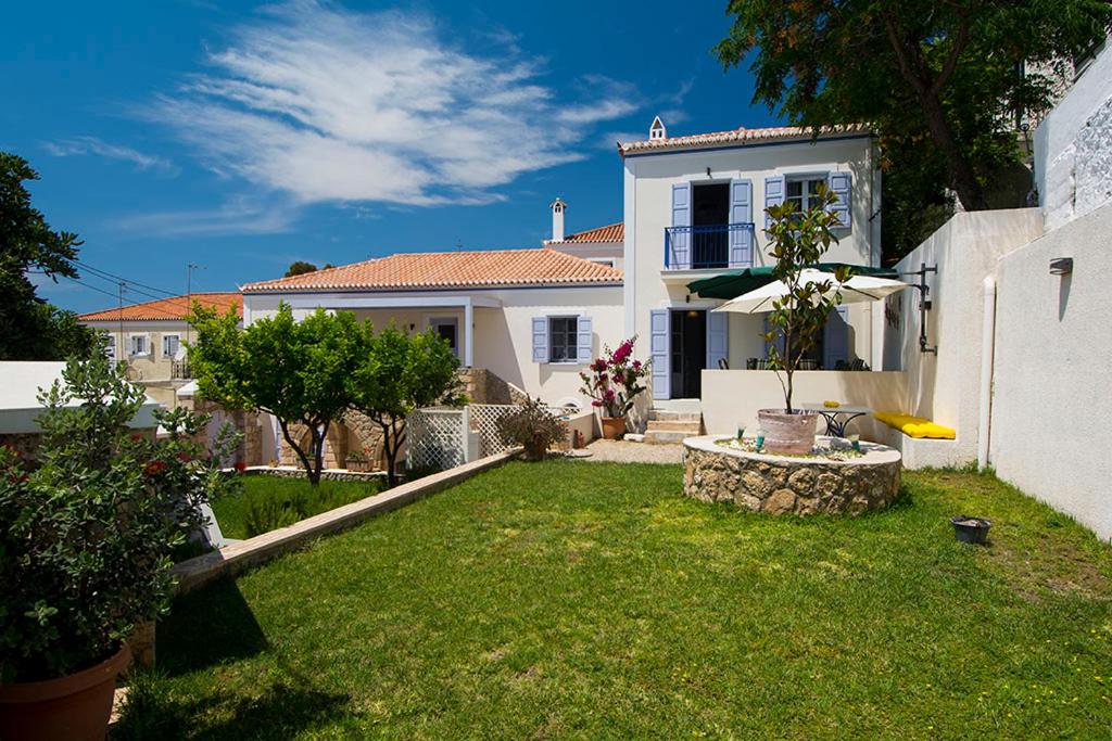 斯派赛斯VILLA AELIA in Spetses - charm & convenience, 2min beach的白色的房子,带绿色草坪的院子