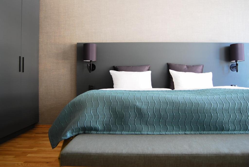 克里斯蒂安桑Hotel KRS的一间卧室配有带两个枕头的绿色床