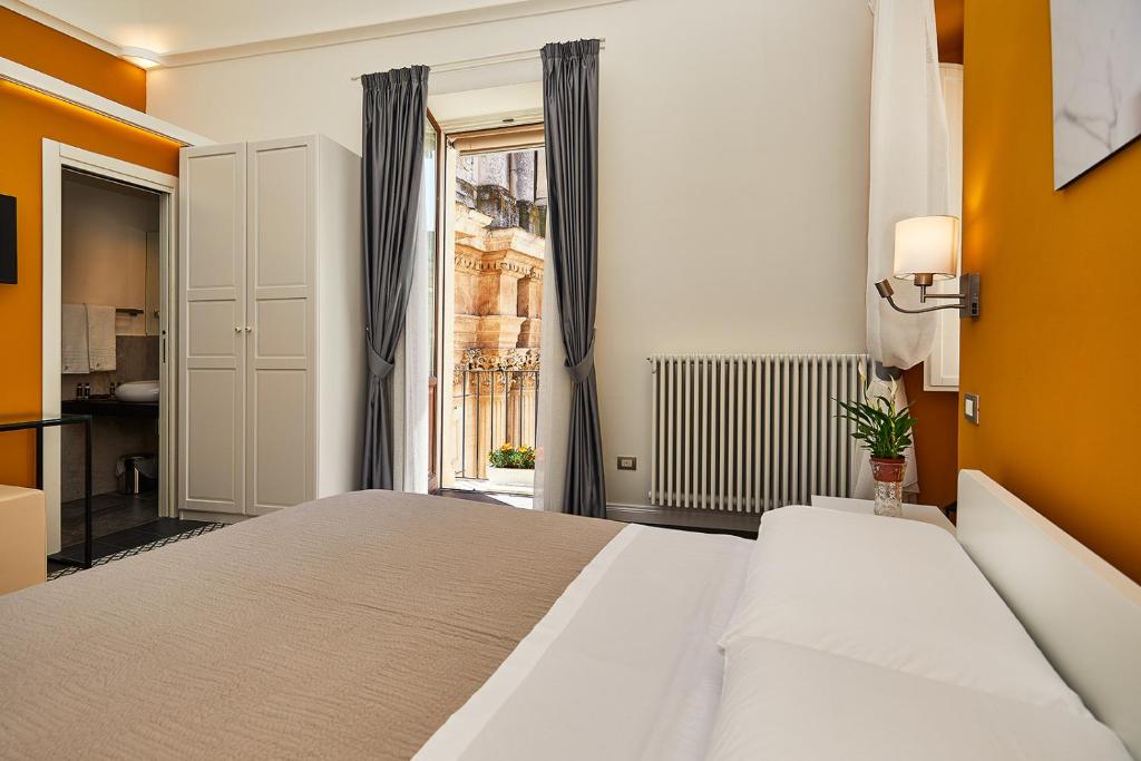 莱切Donna Teresa Guest House的一间卧室设有一张大床和一个窗户。