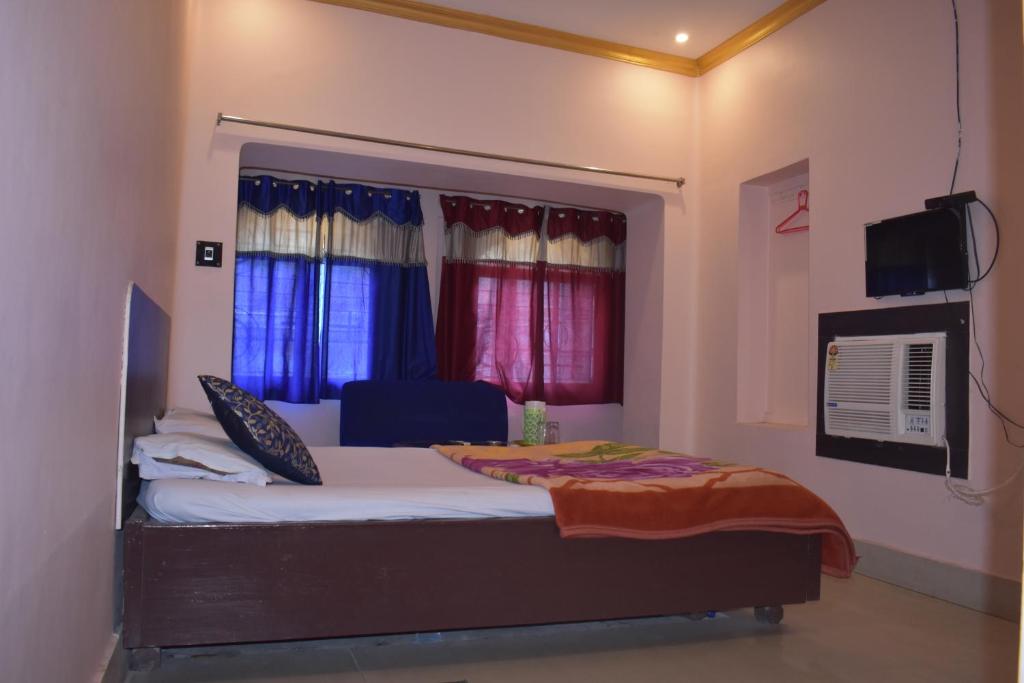 BarddhamānNataraj Hotel and Boarding的一间卧室设有一张床、一台电视和窗户。
