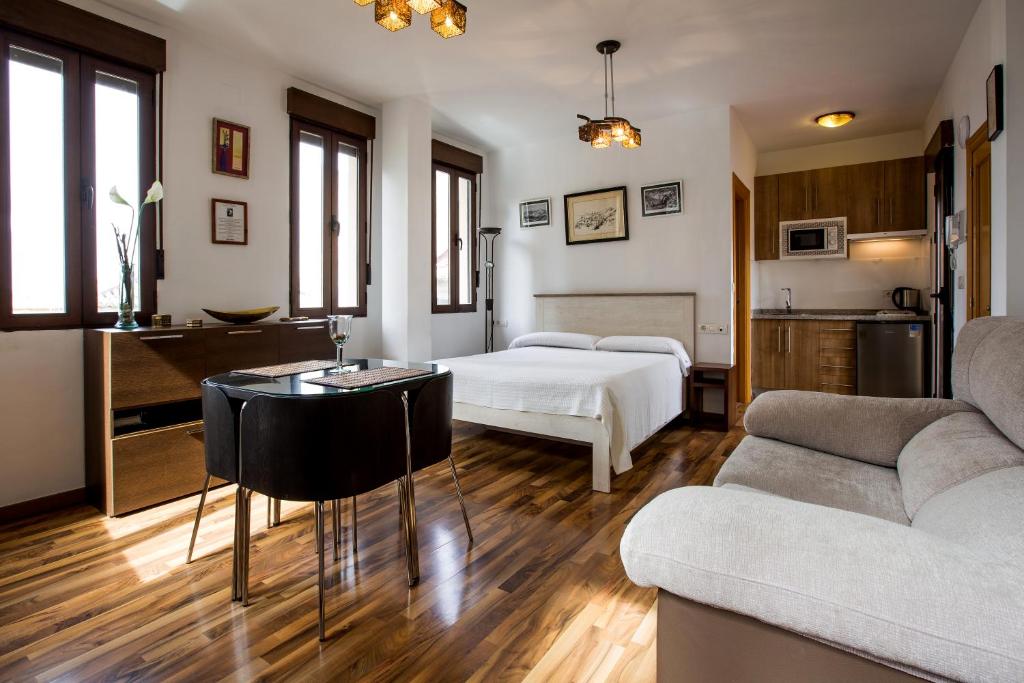 格拉纳达卡萨德拉龙佳公寓的配有床、桌子和沙发的房间
