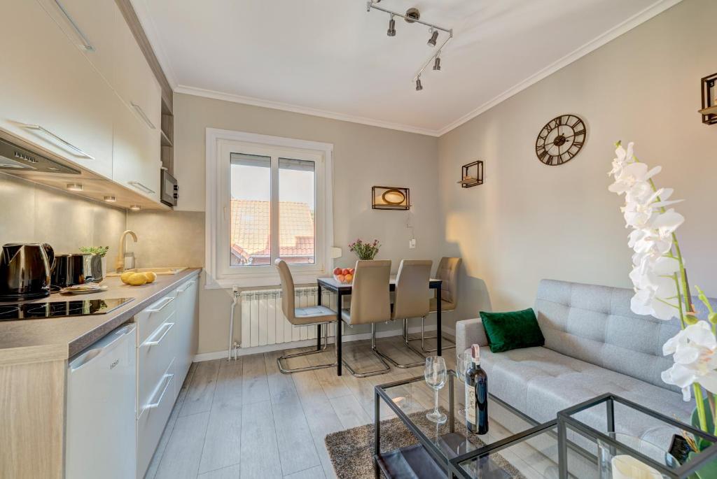 索波特Dom & House - Apartments Villa Elen的厨房以及带沙发和桌子的客厅。