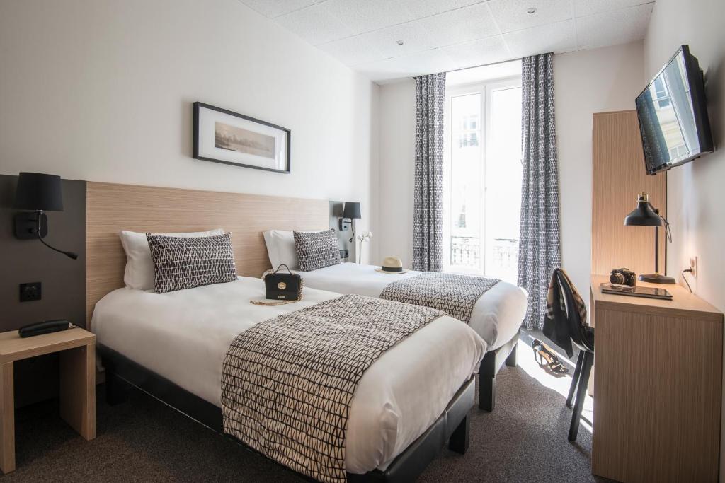 尼斯Hotel Saint Gothard的酒店客房设有两张床和电视。