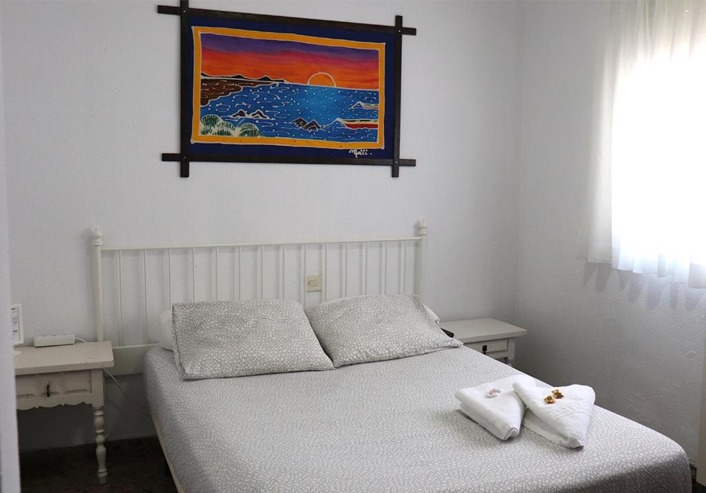 萨拉戈萨Hostal Milmarcos的卧室配有一张床,墙上挂有绘画作品