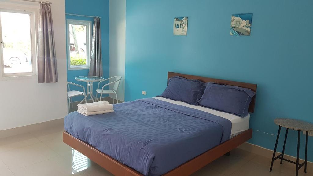 班昌月光度假酒店的一间卧室设有一张床和蓝色的墙壁