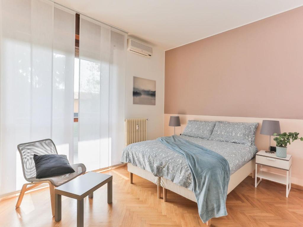 米兰The Best Rent - Big apartment near San Siro stadio的一间卧室配有一张床和一把椅子
