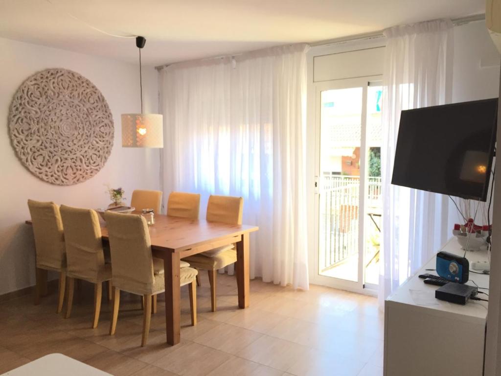 滨海阿雷尼斯BarcelonaVacances-Katrin的一间带木桌和椅子的用餐室