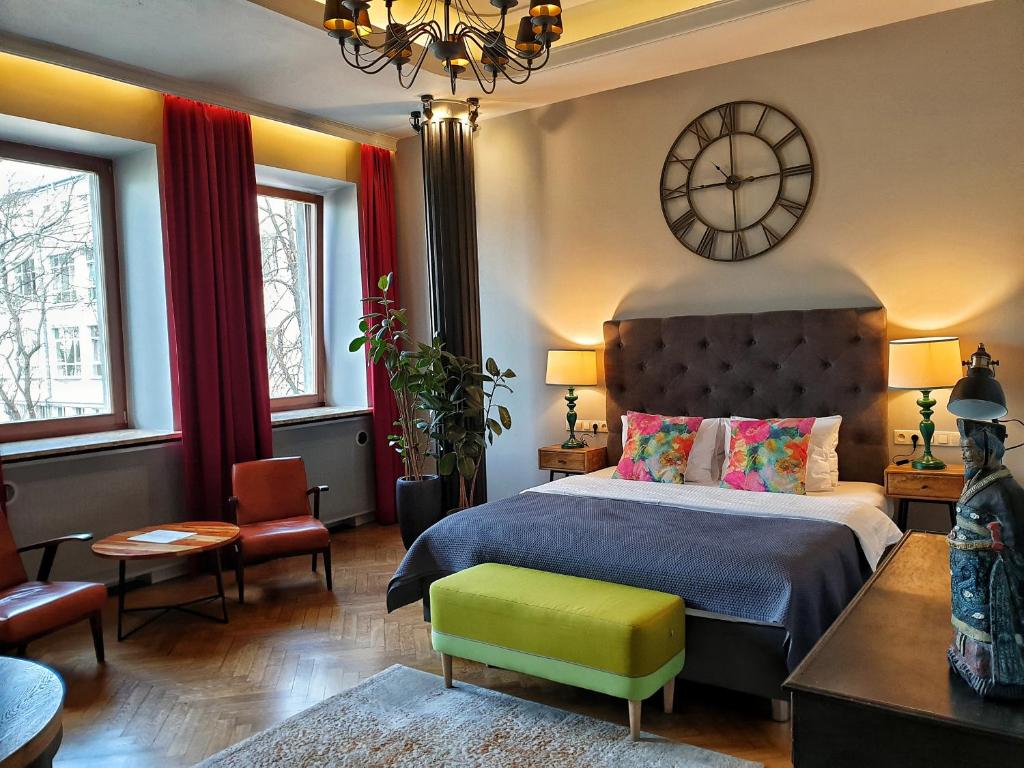 华沙欧迪南卡安眠公寓的卧室配有一张床,墙上挂着一个钟