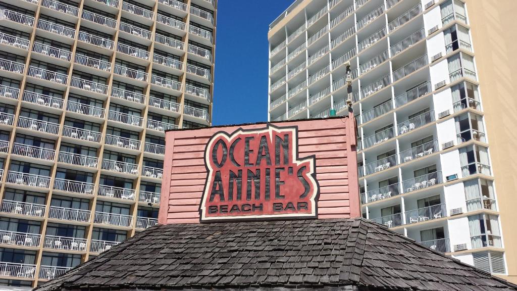 默特尔比奇Ocean Annie's Resorts的粉红色的建筑,上面有标志