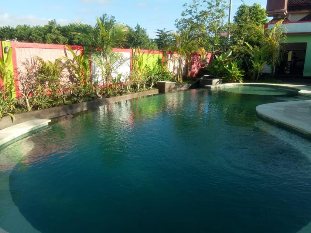 NegaraHOTEL SEGARA MANDALA的庭院里的一个蓝色海水游泳池