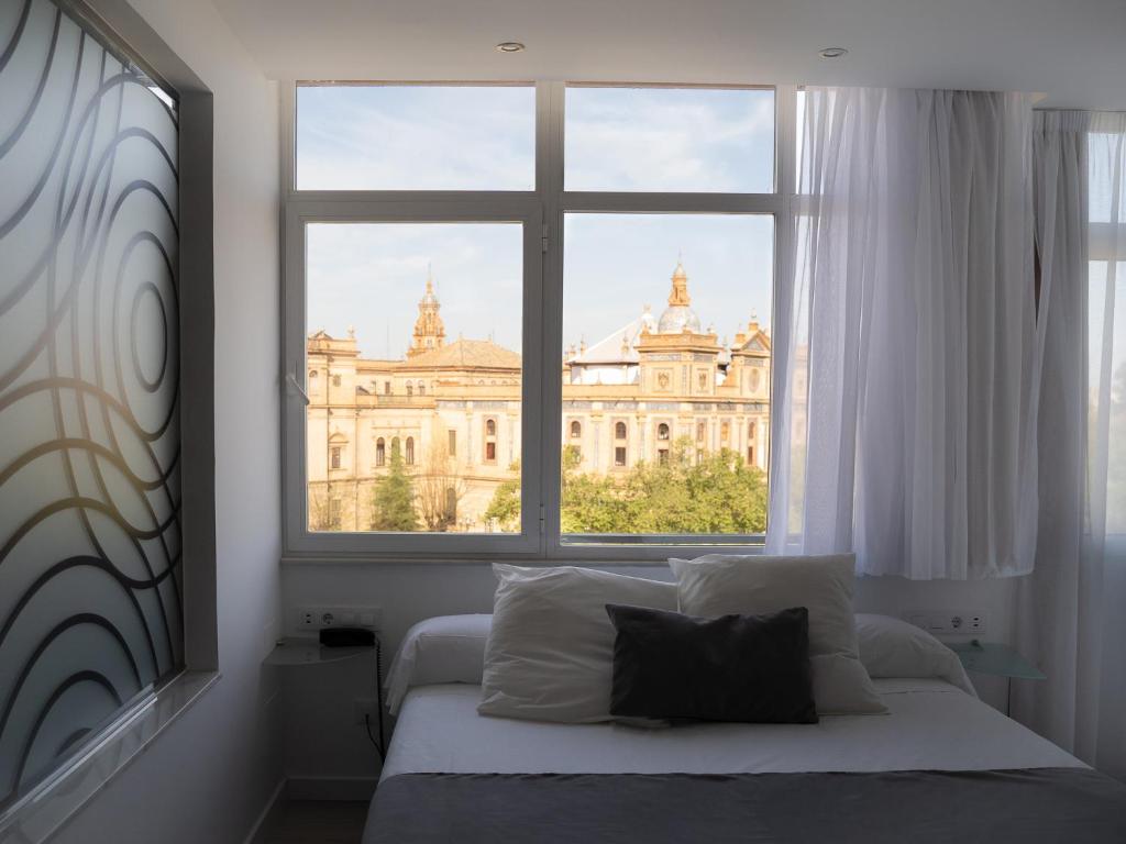 塞维利亚帕萨雷拉酒店的一间卧室设有窗户,享有建筑的景色
