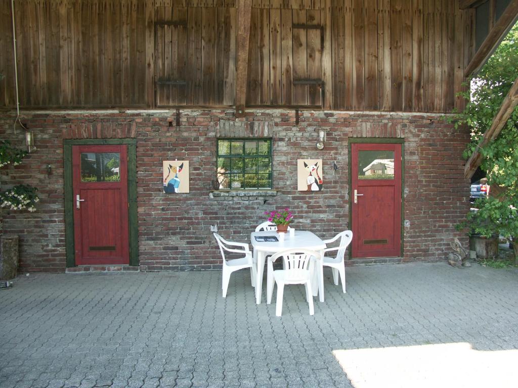 温特贝格Trekkershut Isidorus的砖砌建筑前带桌椅的庭院