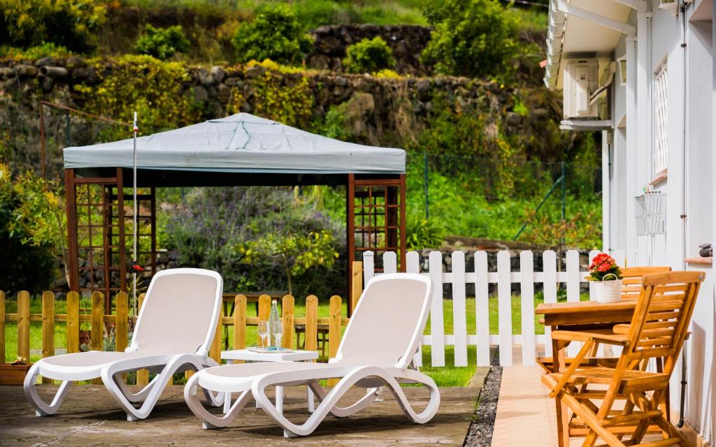 拉奥罗塔瓦Estudio rural - Nature & Relax的天井上配有两把椅子、一张桌子和一把遮阳伞