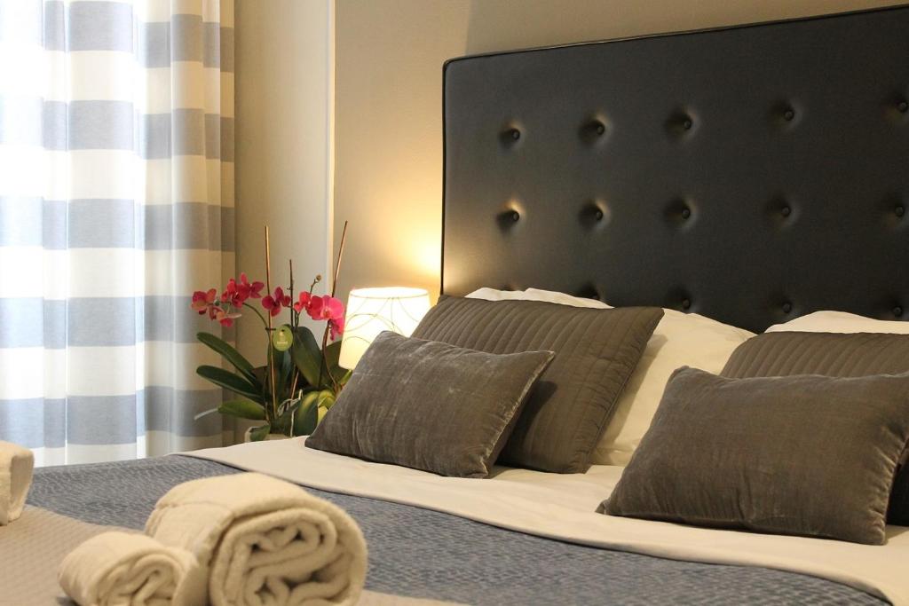 罗马小玫瑰客房旅馆的一间卧室配有一张带黑色床头板和枕头的床。