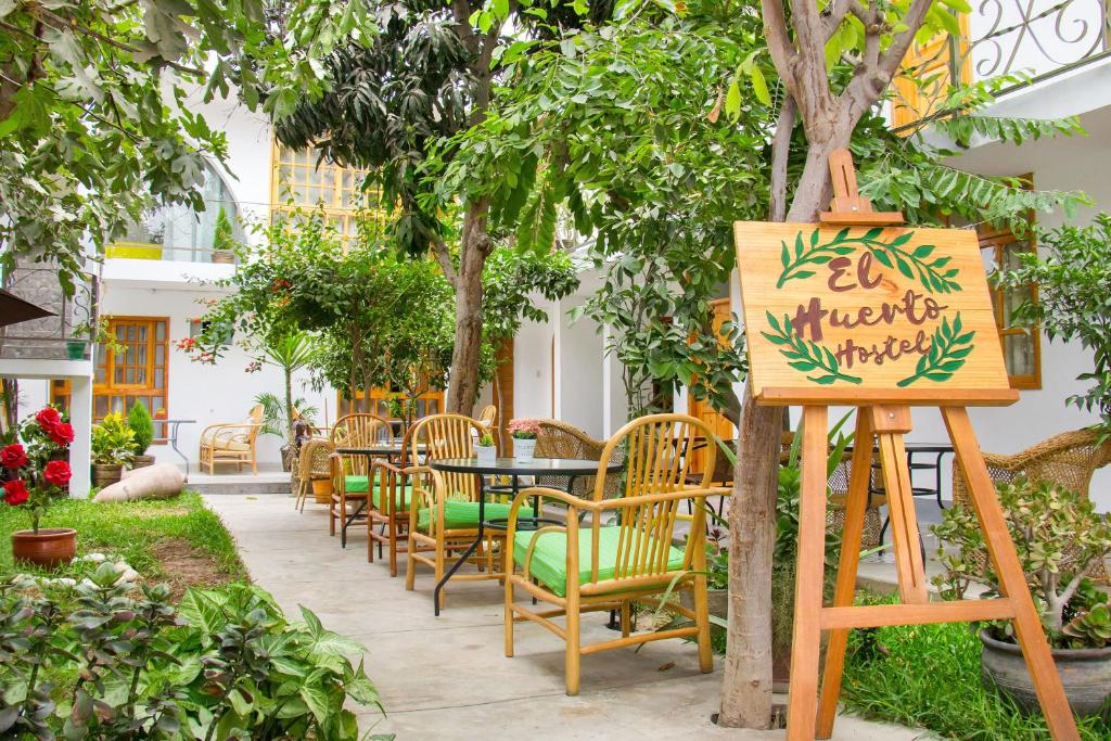 伊察El Huerto Hostel的一个带桌椅和标志的花园