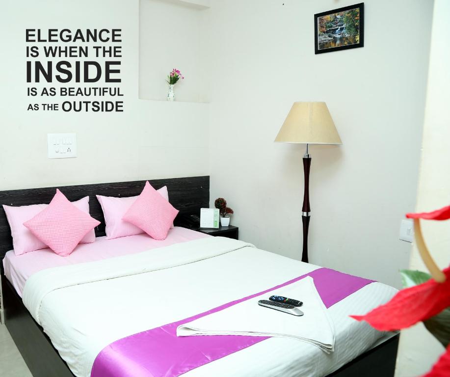 班加罗尔Orange Corner, Near Kempegowda Bangalore international airport的一间卧室配有带粉红色枕头的床