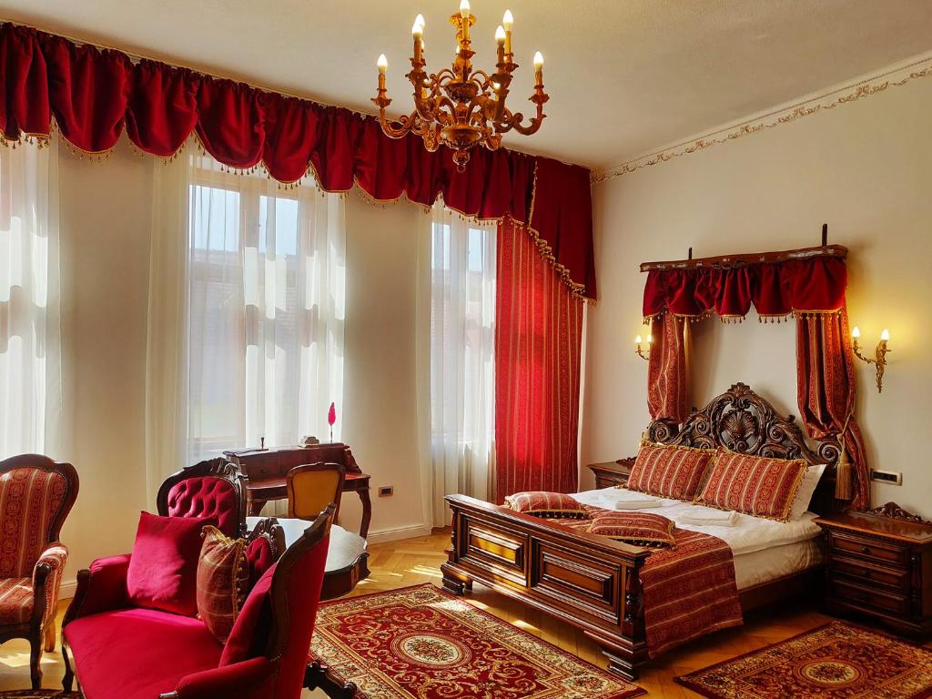 锡比乌Zur Krone的一间卧室配有一张带红色窗帘和吊灯的床。