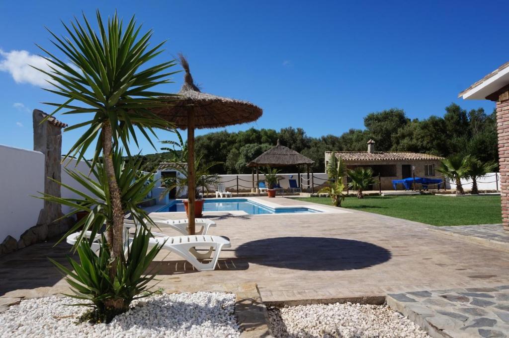 巴尔巴特Villa fuente redonda的一个带椅子和遮阳伞的庭院和一个游泳池