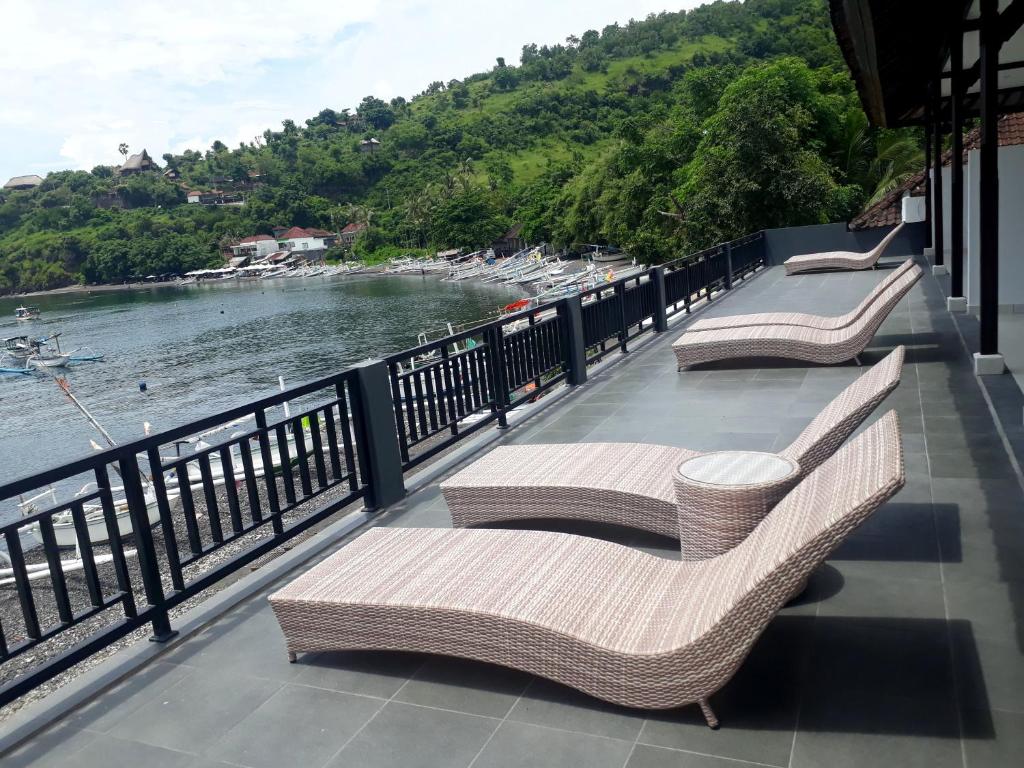 艾湄湾加郎强仁简易别墅的三个柳条长椅,位于一个俯瞰水面的阳台