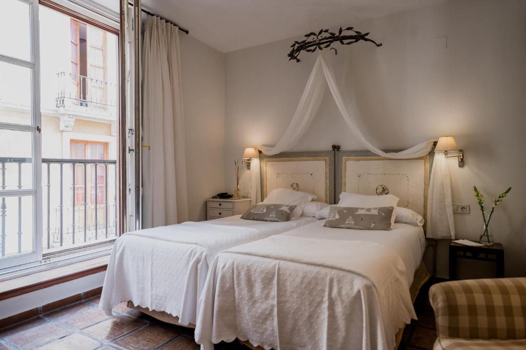 格拉纳达洛斯纳瓦斯宫酒店的卧室配有一张带两个枕头的大白色床