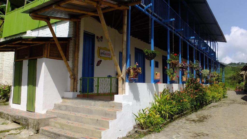 CórdobaSoñarte Reserva Natural的一座蓝色门、楼梯和鲜花的建筑