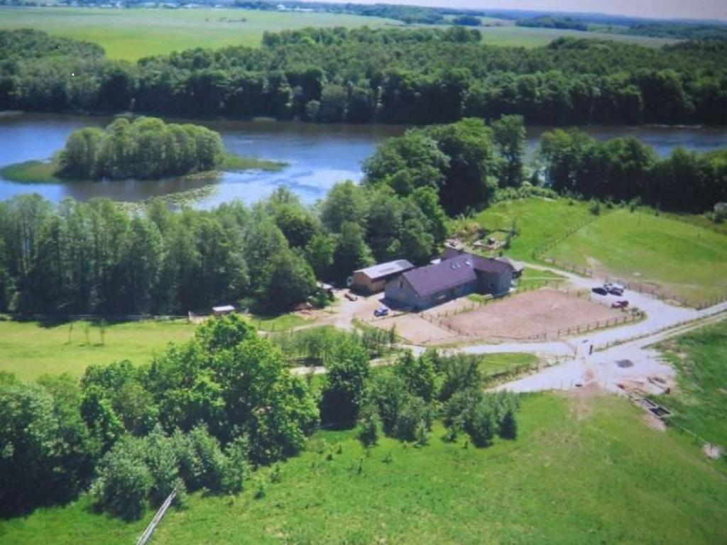 Czarna DąbrówkaStajnia Grazyny Mikorowo 46的享有河边房屋的空中景致