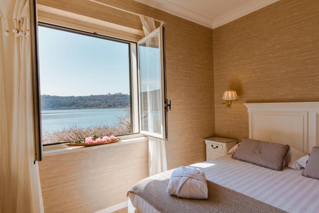 冈多菲堡库拉湖酒店的一间卧室设有一张床和一个大窗户